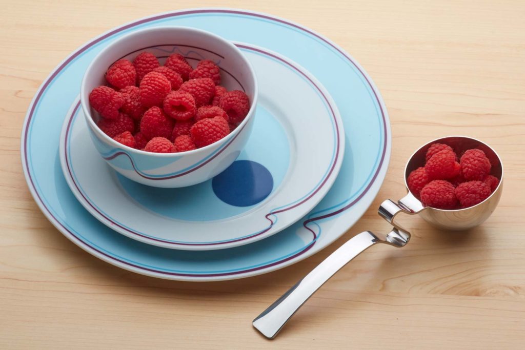 Raspberries in a Livliga portion control bowl on Halsa Portion Control Plates, with a LivSpoon filled with raspberries beside.